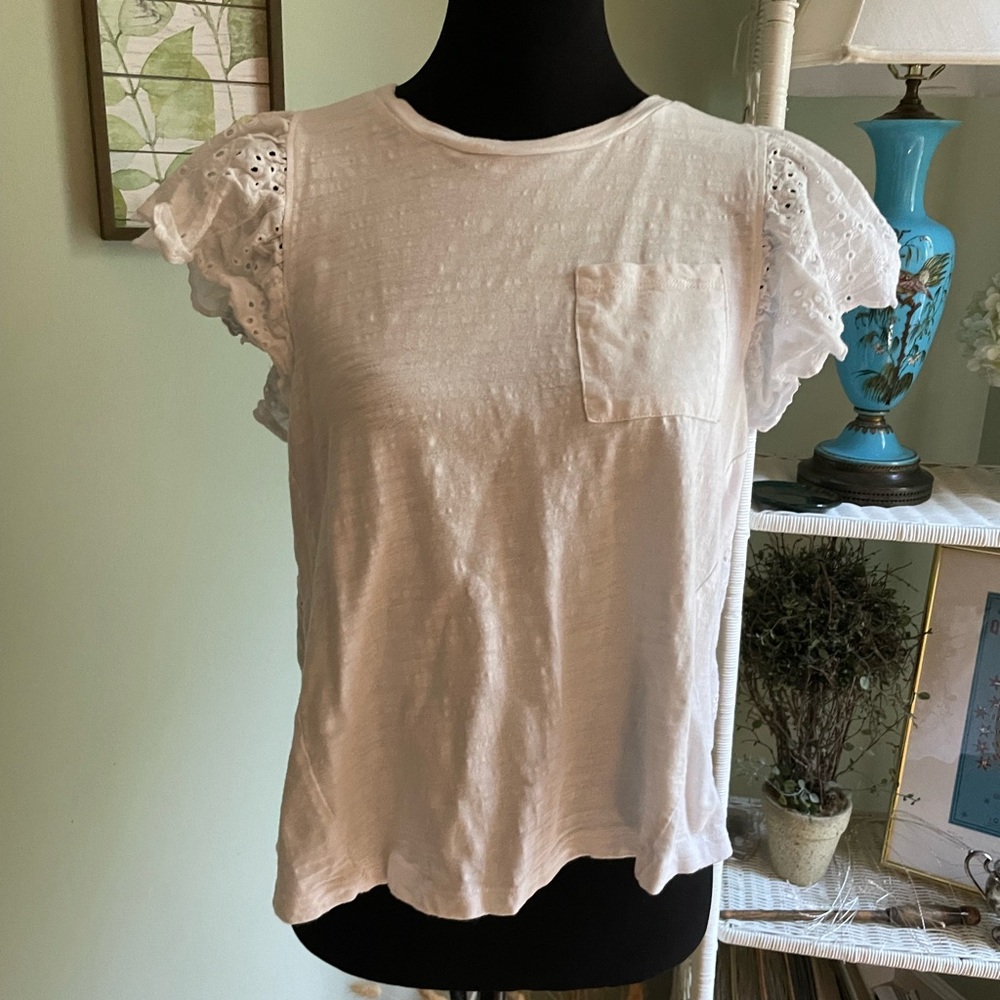 White t-shirt with pocket on front, back is lace-like material.